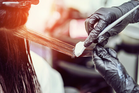 Hairdresser applies dye on a woman's hair